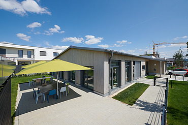 Foto Gebäude mit gepflasterter Terrasse und Sonnenschirmen