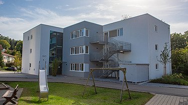 Foto Gebäuderückseite mit Spielplatz im Vordergrund