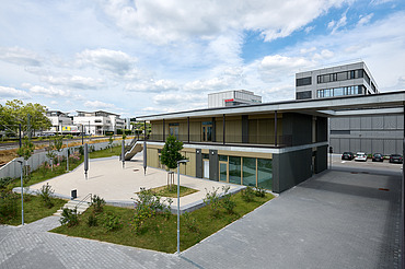 Foto Jugendzentrum von außen mit großem Vorplatz und Bahnschienen an der Seite