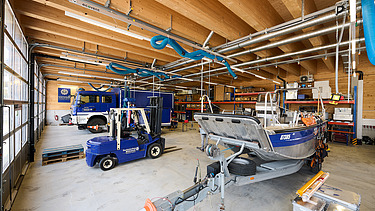 Foto im Inneren der KfZ-Halle mit Rettungsboot und Rettungsfahrzeug