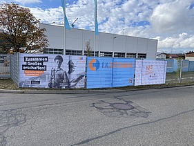 Zaun mit Bannern der Firma