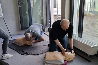 2 Männer, die an einer Puppe Reanimation üben