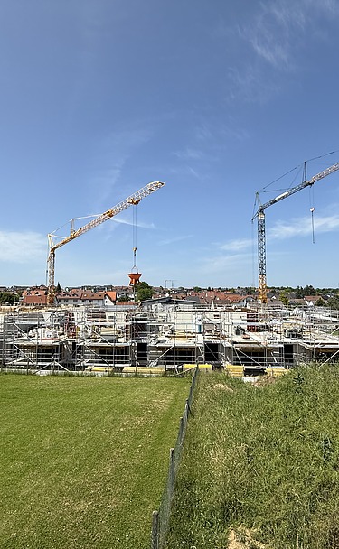 Foto Baustelle von weit weg mit grüner Wiese und blauem Himmel