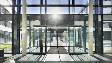 Foto Innenaufnahme vom Eingang mit viel Glas und Sonne