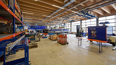 Foto im Inneren der KfZ-Halle mit Rettungsboot und Rettungsfahrzeug