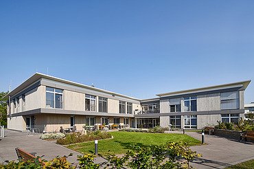 Foto von außen mit 2 Gebäudeteilen und Eingangsbereich