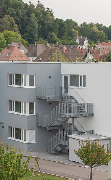 Foto von Gebäude von weiter weg mit Straße, Eingang 