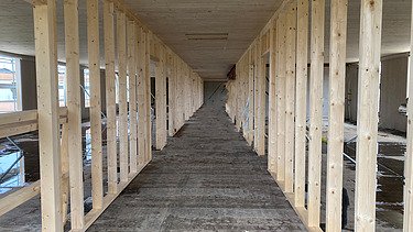 Foto eines Gang mit Sichtbeton und Holzständern