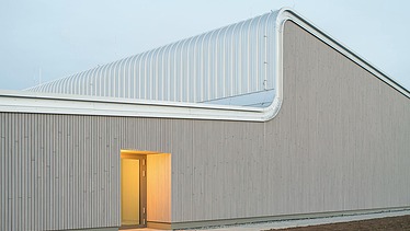 Foto Seite der Halle mit markanten Dachschwung