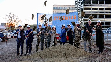 Foto von Menschen, die mit einem Spaten Erde in Luft werfen