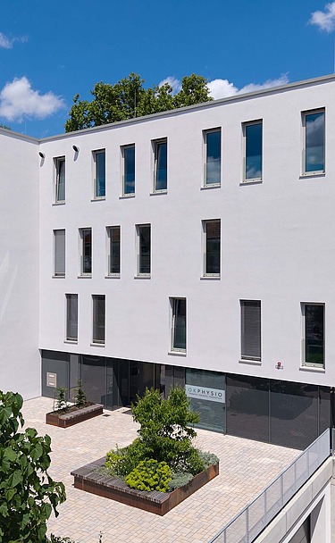 Frontalansicht Gebäude mit Vorplatz 