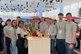 Foto von jungen Menschen an einem Messestand
