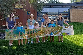 Foto von Kindern, die ein gemaltes Danke-Schild zeigen