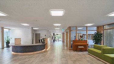 Foto innen mit Empfangsbereich und grünem Sofa