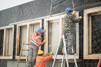 Foto von Männern, die Bewehrungsarbeiten an Fensteraussparungen ausführen