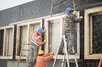 Foto von Männern, die Bewehrungsarbeiten an Fensteraussparungen ausführen