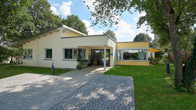 Foto Eingangsbereich mit gepflastertem Weg und grüner Wiese