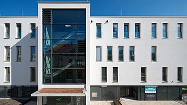Frontalansicht Gebäude mit Glasfassade des Treppenhauses