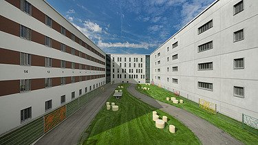 Foto Innenhof zwischen 2 Gebäuden mit Wiese und Sitzgelegenheiten