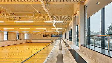 Innenaufnahme von Galerie auf Sporthalle nach unten mit Tribünensitzplätzen