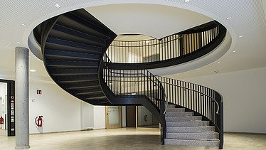 Foto im Innenbereich mit schwarzer Wendeltreppe