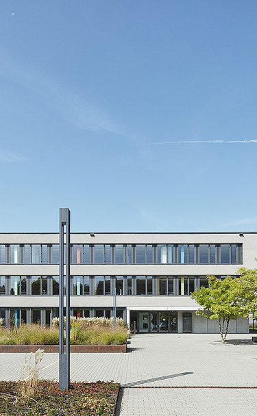 Foto Gebäude mit Vorhof und Bäumen 