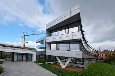 Foto Eingangsbereich Gebäude mit gekrümmter Fassade und V-förmiger Stütze