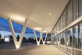 Foto von Eingangsbereich Gebäude bei Dämmerung mit V-Stützen aus Beton