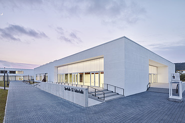 Foto Eckansicht Sporthalle mit gepflastertem Weg und Eingang