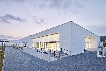 Foto Eckansicht Sporthalle mit gepflastertem Weg und Eingang