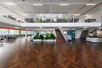 Innenaufnahme Mensa mit dunklem Parket und Blick ins Obergeschoss
