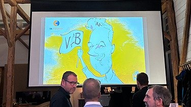 Foto von 1 Mann von dem gerade eine Karikatur gezeichnet wird