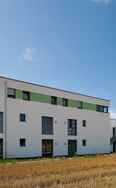 Foto Gebäudeecke mit Feld im Vordergrund