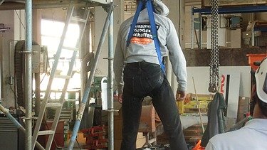 Ein Mitarbeiter hängt an einer Absicherung zur Höhenrettung
