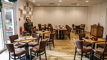 Foto Gemeinschaftsraum mit Tischen, Stühlen und Klavier