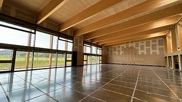 Innenaufnahme mit Sporthallenboden und Holzdecke