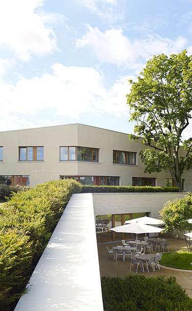 Foto Gebäude mit Blick auf Terrasse mit Stitzgelegenheiten
