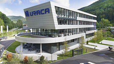 Foto Gebäude mit Schriftzug URACA  und rundem  Vordach