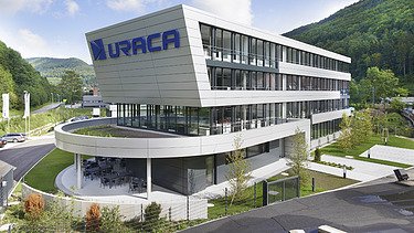 Foto Gebäude mit Schriftzug URACA  und rundem  Vordach