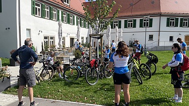 Foto von Menschen mit Fahrrad vor einem Restaurant