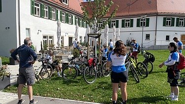 Foto von Menschen mit Fahrrad vor einem Restaurant
