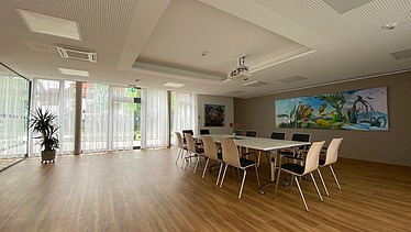 Foto im Innenbereich mit Sitzbereich und Gemälde an der Wand