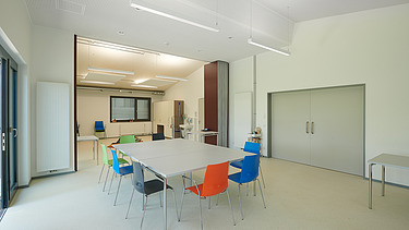 Foto Innenbereich Tisch mit bunten Stühlen 