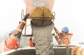 Foto von 2 Männern, die flüssigen Beton verarbeiten