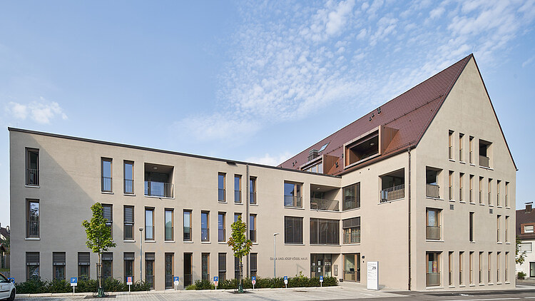 Foto von einem beleuchteten Gebäude mit großer Glasfront in Abendstimmzng