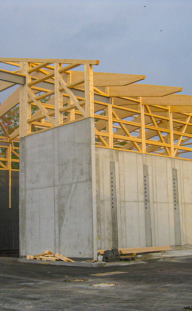 Foto während Bauphase Betonwände und Holzdachkonstruktion