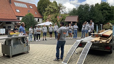 Auszubildende hören den Anweisungen der Fachkraft für Arbeitssicherheit zu 