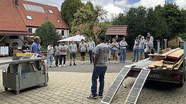 Auszubildende hören den Anweisungen der Fachkraft für Arbeitssicherheit zu 