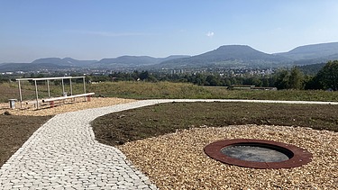 Foto eines Bewegungsgarten mit Bergen im Hintergrund