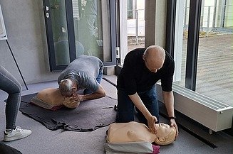2 Männer, die an einer Puppe Reanimation üben